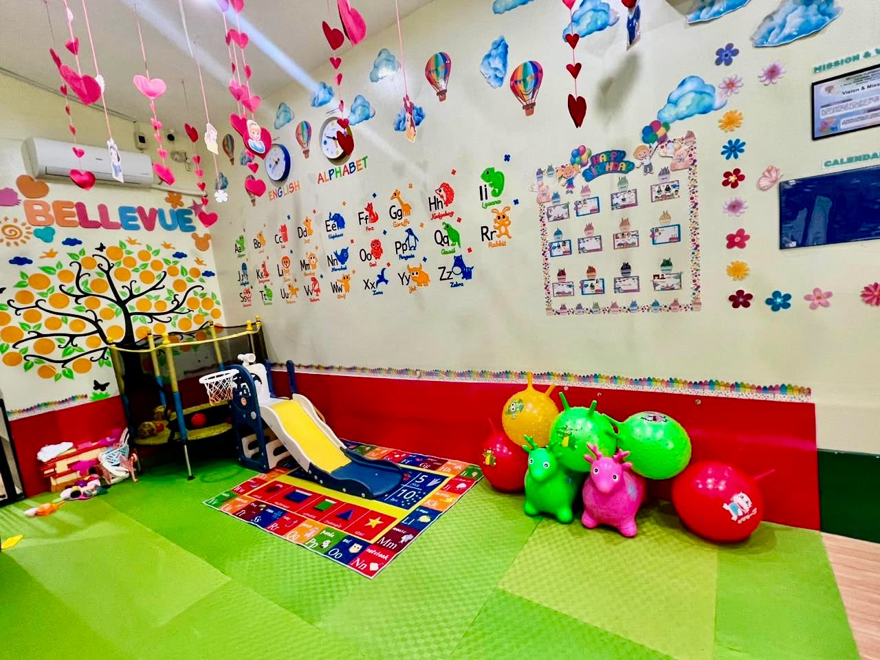 The Bellevue playroom with slide, trampoline and colorful alphabet wall